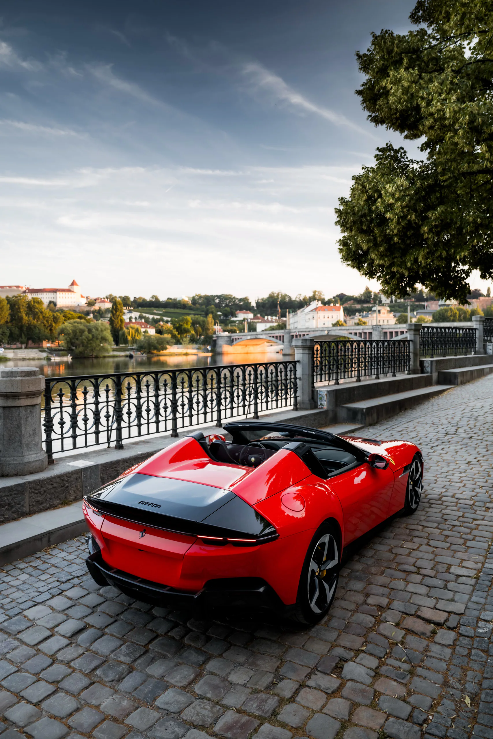 Ferrari 12Cilindri Spider on the river embankment with the castle behind