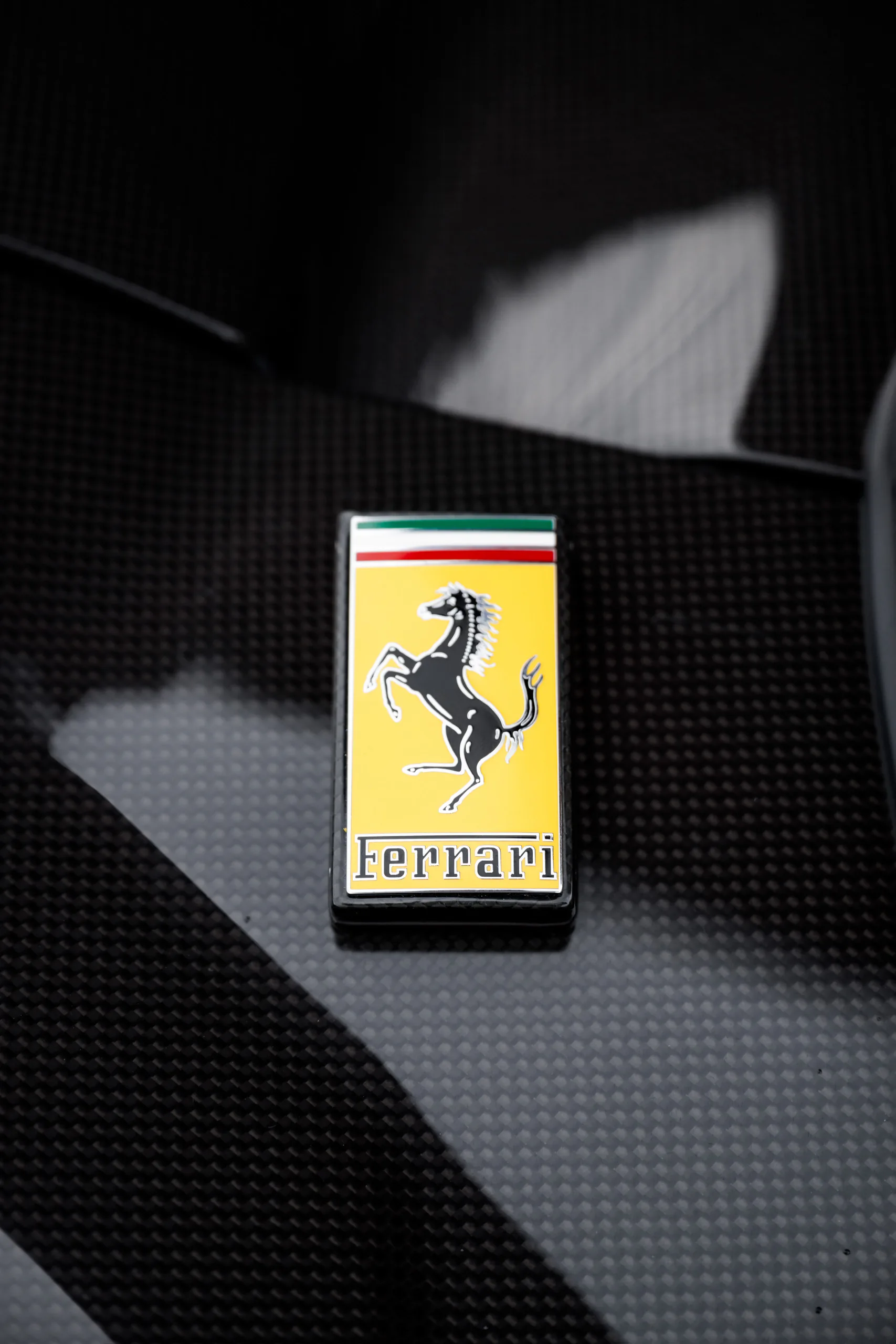 Ferrari shield badge on carbon fibre