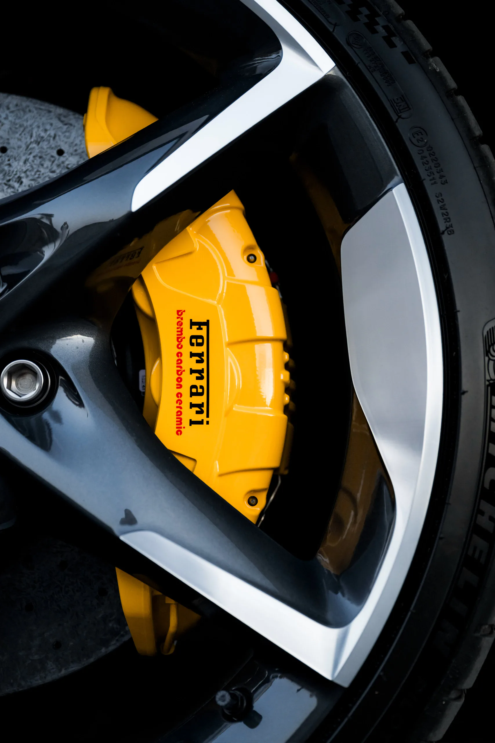Yellow Brembo carbon-ceramic caliper behind a diamond-cut wheel