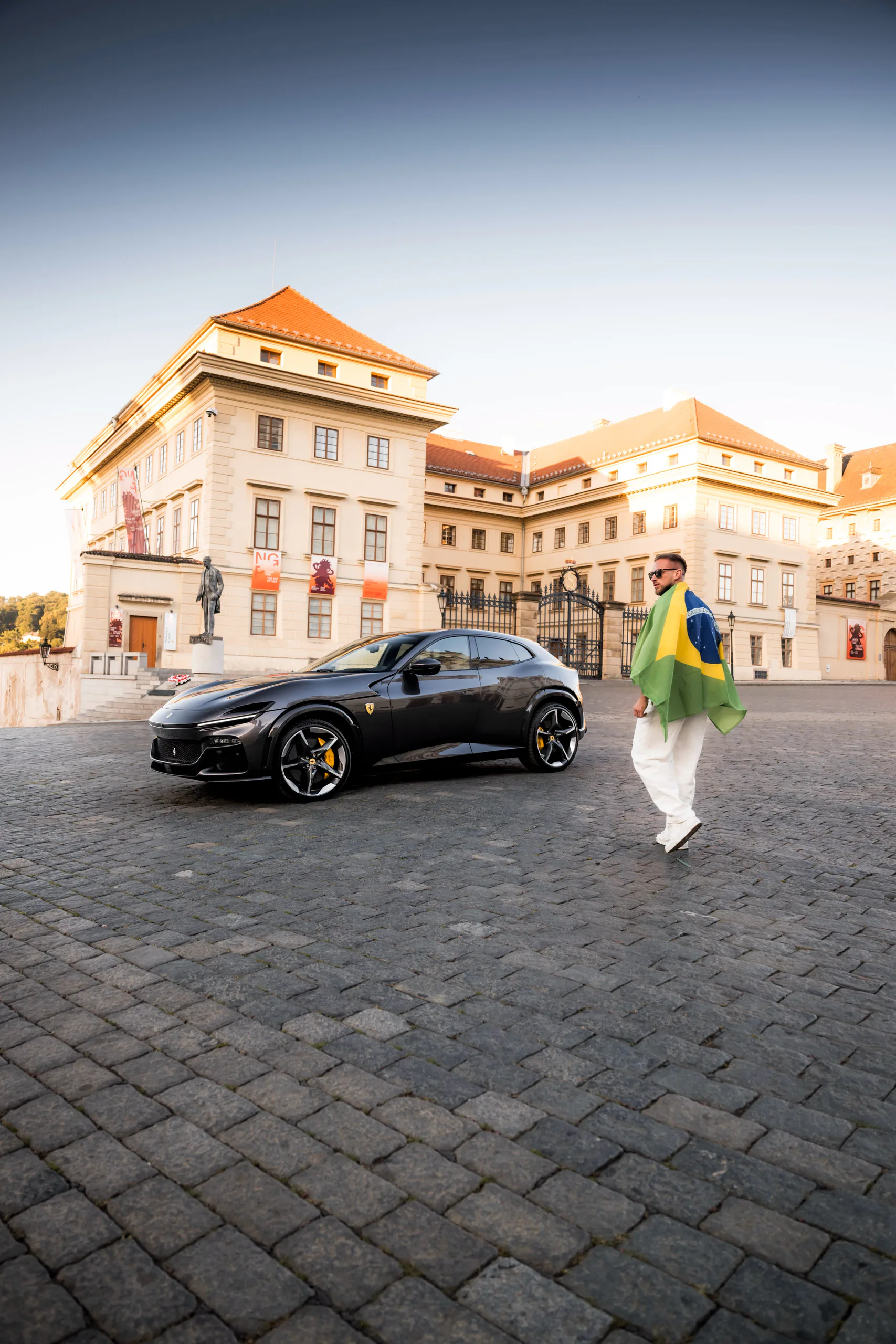 A client walking towards a Ferrari Purosangue on Hradčany Square